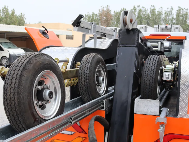 AQUILA 100 fork cradling the vehicle's wheels during a lift.