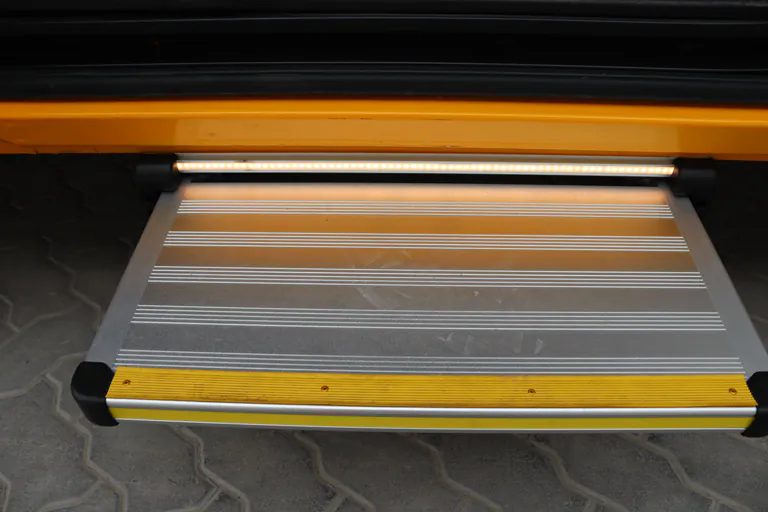 Pull-out aluminium access step extended beneath the rear of the vehicle with a lighting strip above