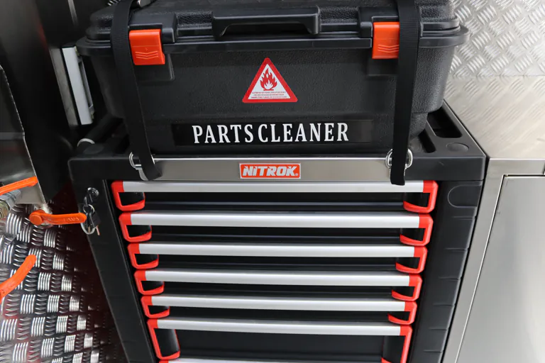 Multi-drawer tool unit with a parts cleaner mounted above it inside the cabin