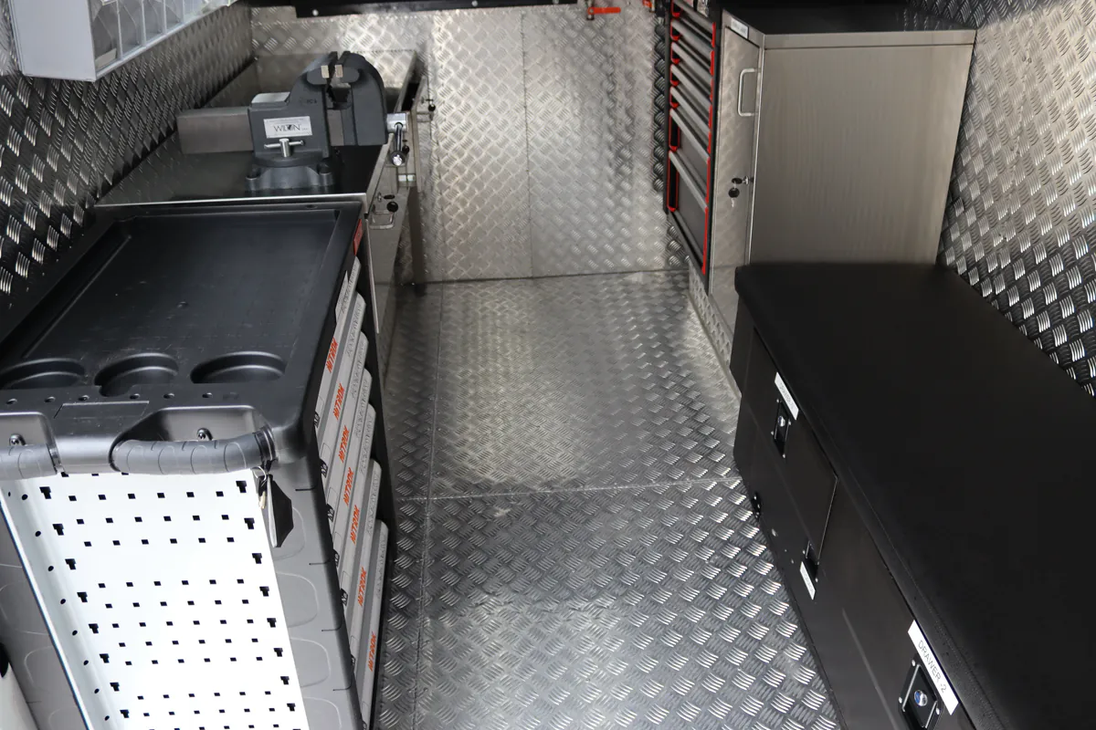 Integrated workbench with a bench vice mounted at the end, above a bank of tool drawers